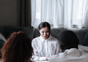 A diverse group meeting with a social worker in a cozy home setting, discussing important documents.